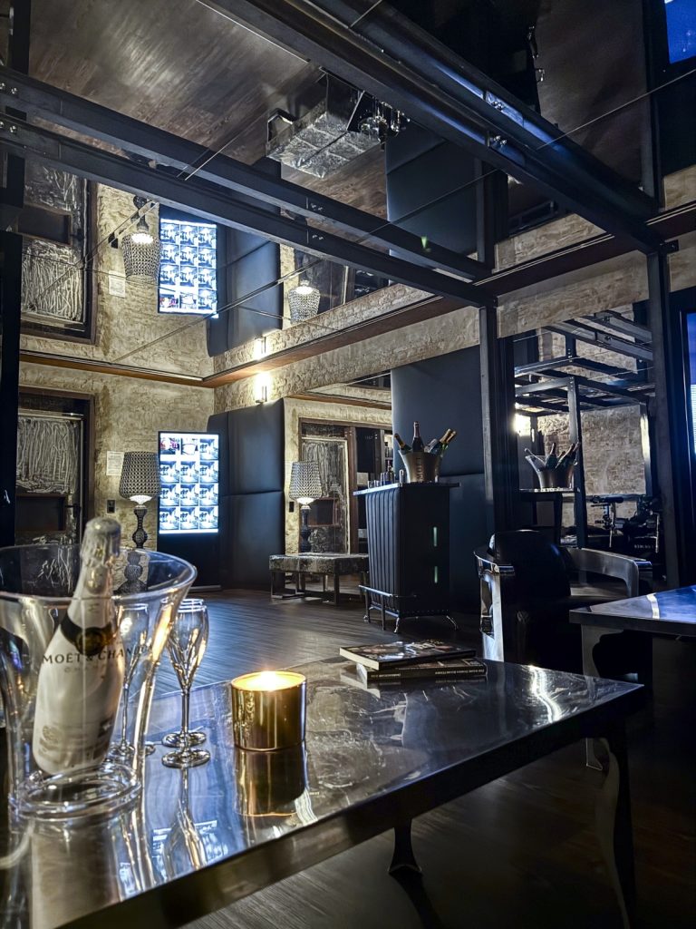 Exklusive Lounge im Bordell mit Champagnerkühler, Gläsern und stilvoller Einrichtung bei Kerzenschein.