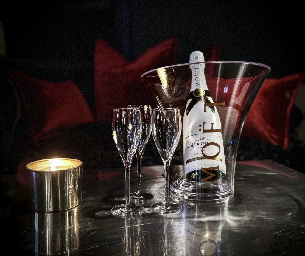 Nahaufnahme eines Moët & Chandon Champagners mit Gläsern und Kerze in der luxuriösen Lounge im Bordell Herrenhaus in Berlin