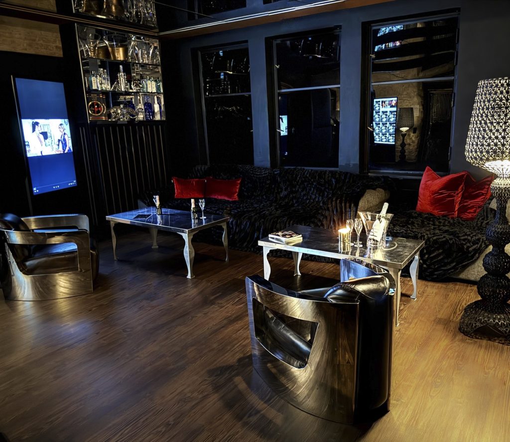 Elegante Sitzecke mit Designerstühlen, Sofas und Champagner in der exklusiven Lounge des Bordell Herrenhaus in Berlin